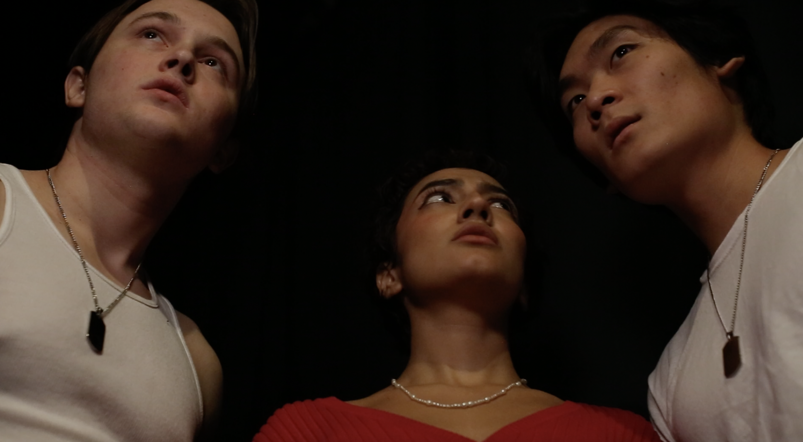 Three actors stand very confused backstage, with only their heads visible.